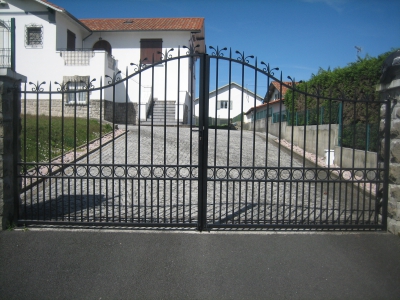 Portail d’un portail en forme chapeau de gendarme avec double barreaudage en soubassement. (Anglet 64).